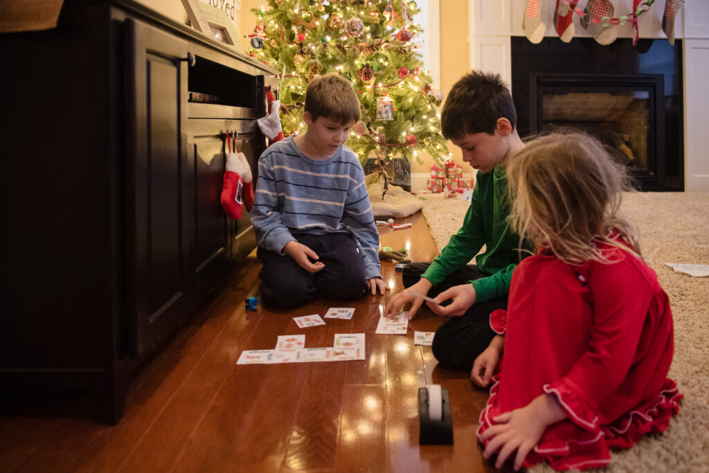 kids cutting up the pieces for the elf on the shelf scavenger hunt