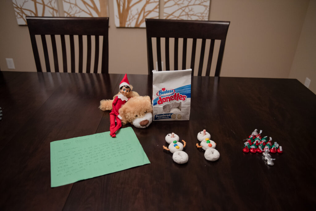Elf on the shelf with donut snowmen and Hershey kisses Christmas trees