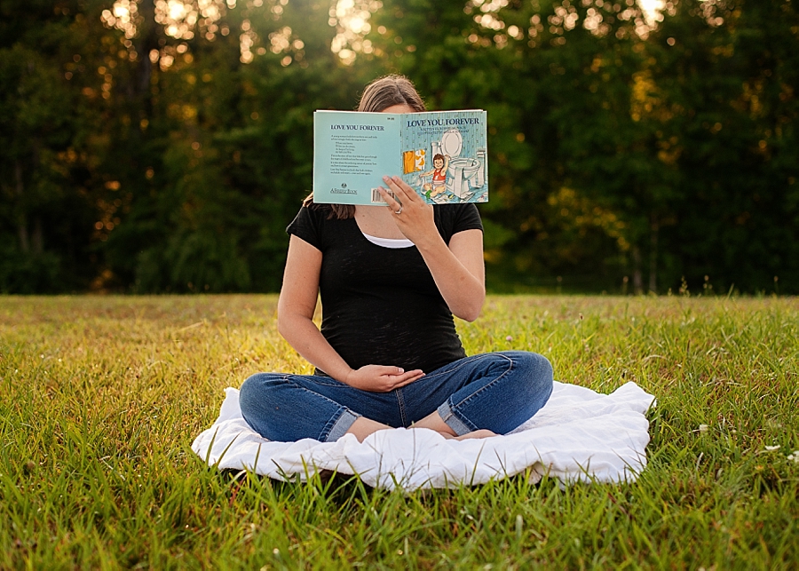 Mother-to-be holding book Love You Forever faceless image 