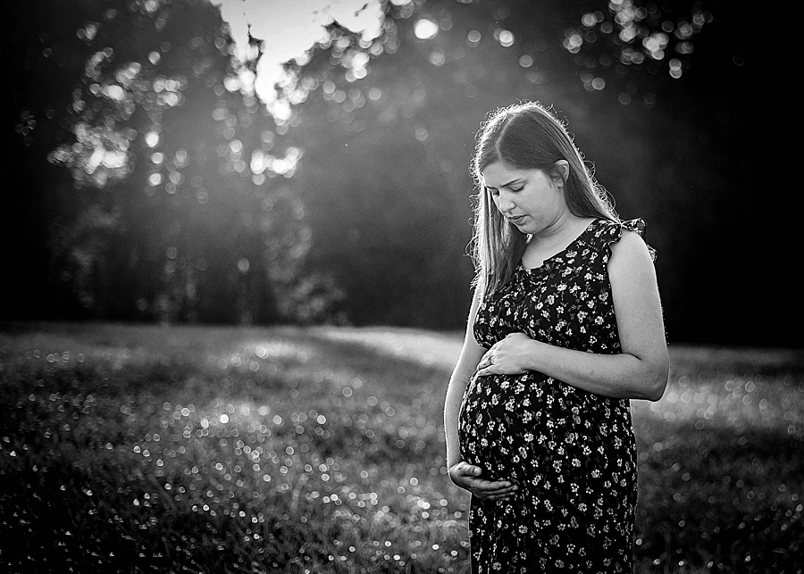 Maternity hands on baby bump black and white backlight outdoor 
