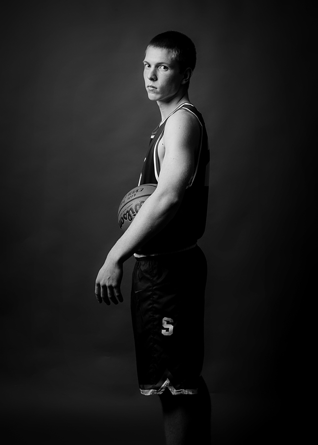 Senior basketball player holding ball - black and white