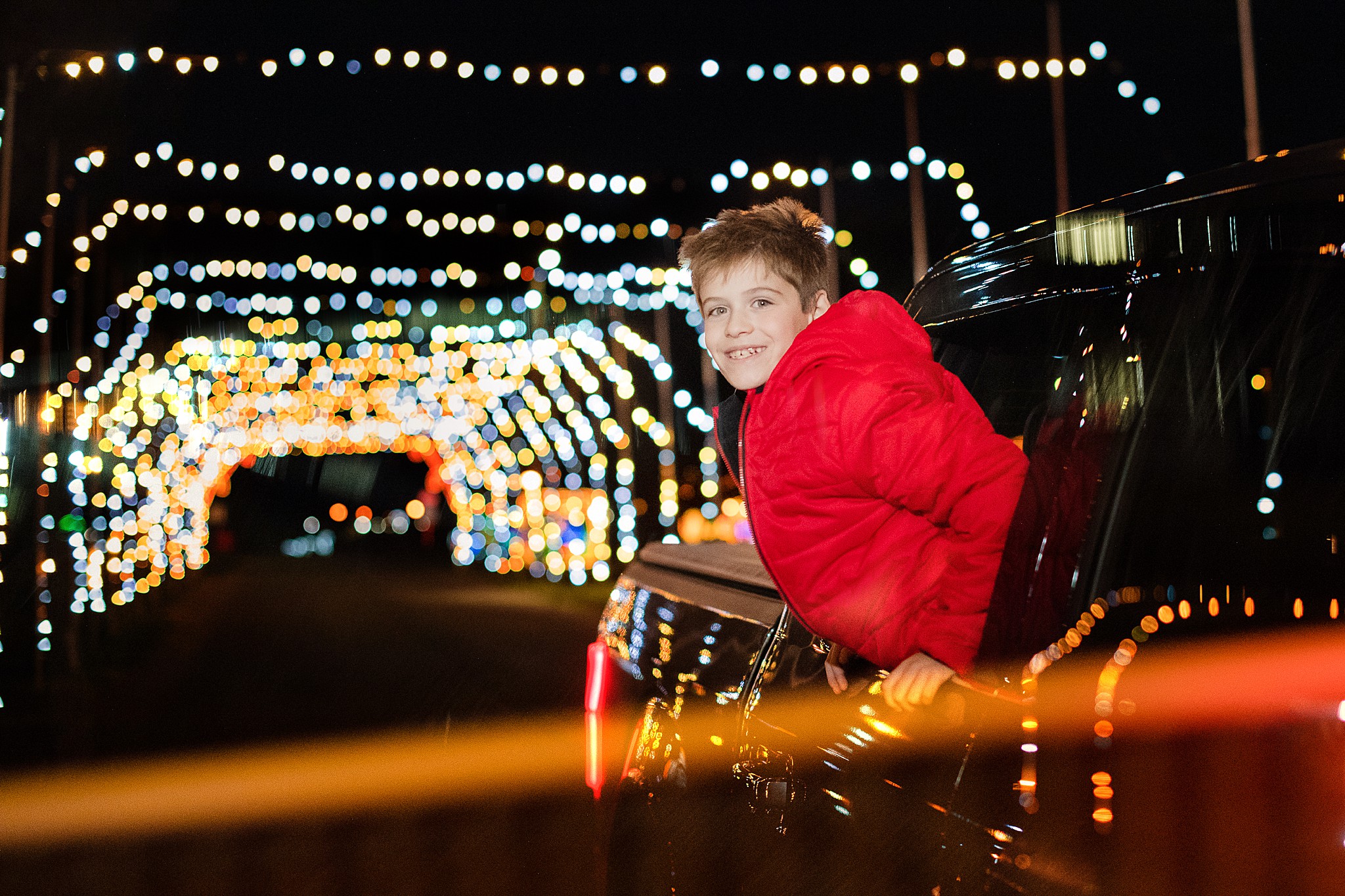 Light Overlay Boy enjoying Christmas lights in a car