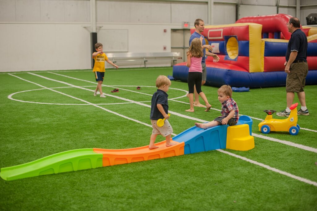 toddler slide and inflatable bounce house on turf at elite sports center