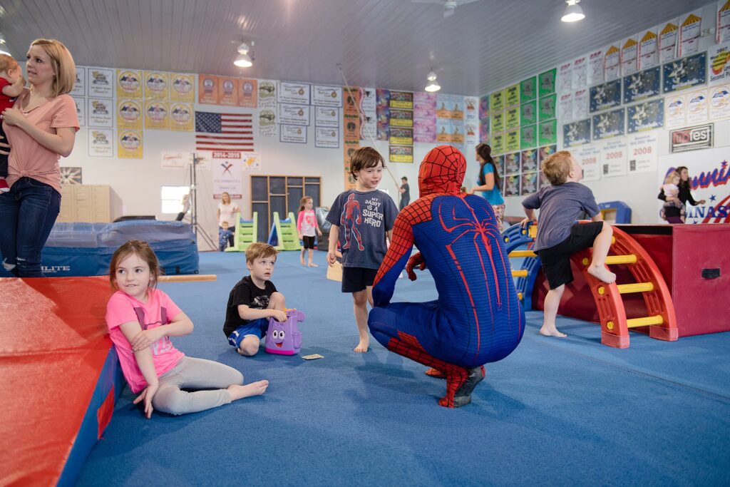 boy talks to spiderman character at gym play party