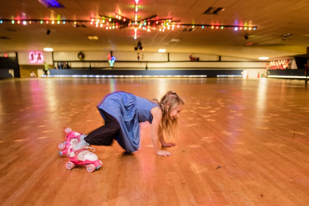 little girl in pink skates tries to skate and dance at skate country roller rink 