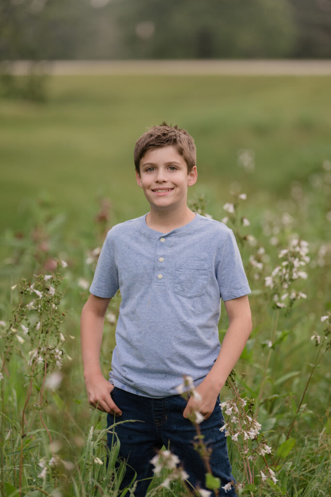 Boy posing in a field for a photography session near Marietta, OH. Lori Pickens Photography took the picture and is based out of Parkersburg, WV