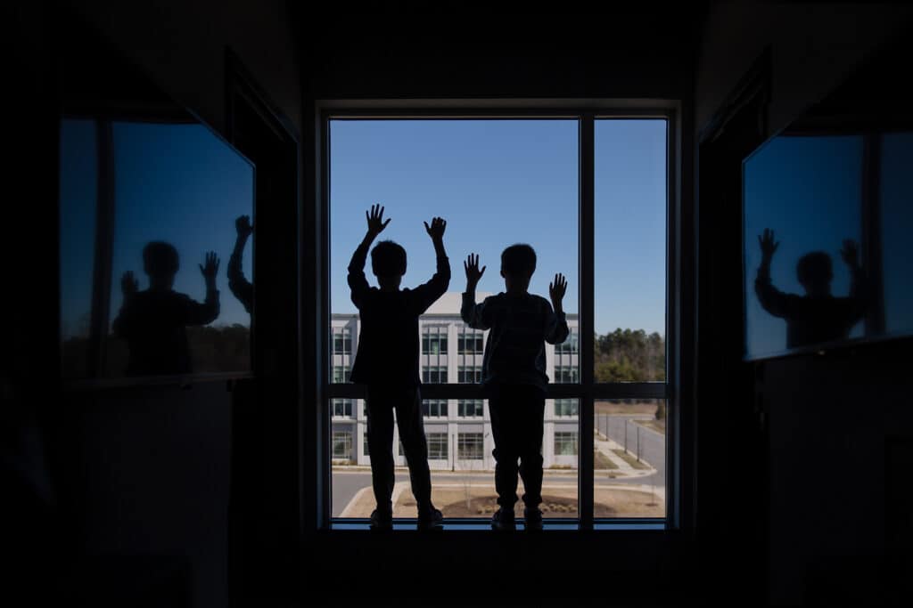 silhouette of boys in window