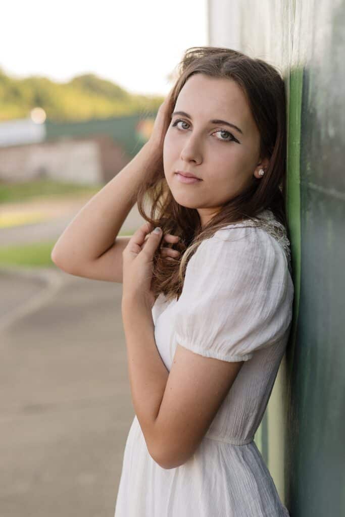 Senior Girl Posting for Senior Photography Session near Marietta OH.  Girl is touching her hair and has a soft facial expression