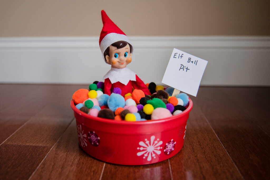 Elf on the shelf in a bucket of pom pots