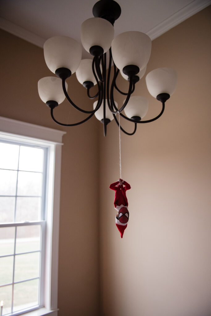 Spiderman Elf on the Shelf hanging from Light fixture