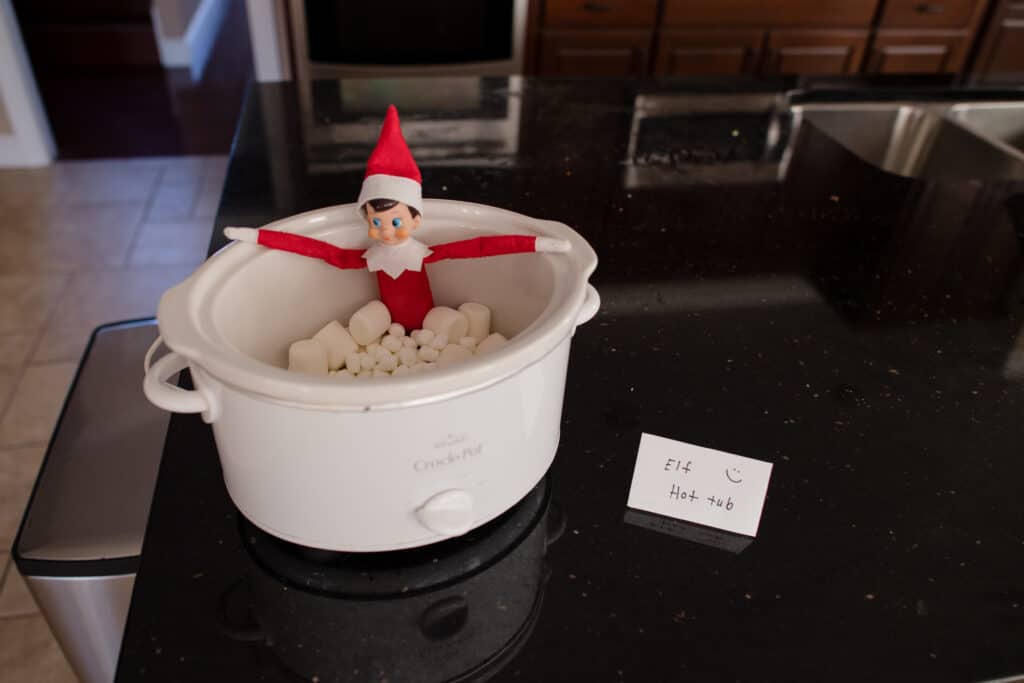 Elf on the Shelf taking a bath in a crockpot with marshmallows