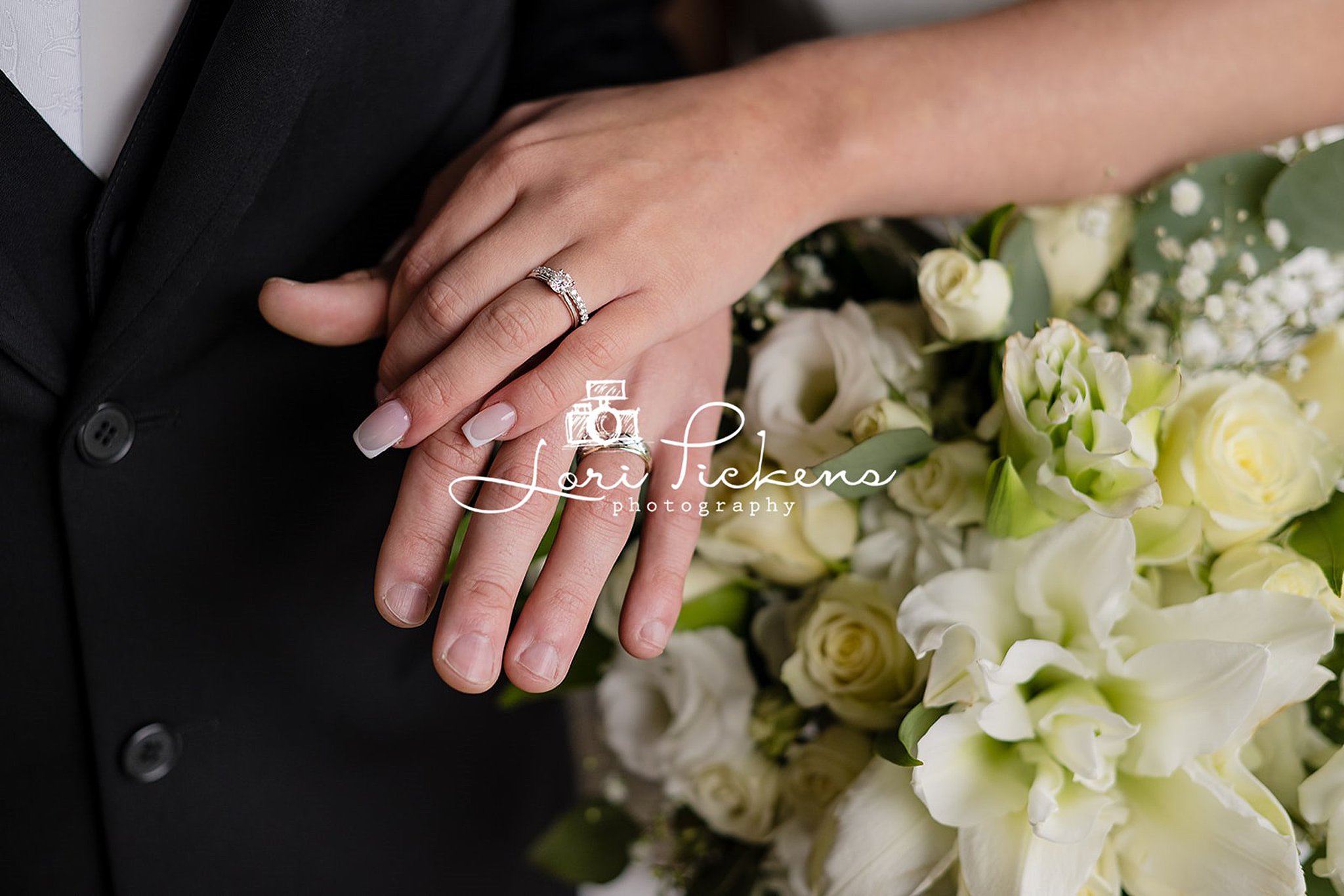 Details of newlywed's ring hands touching over a bouquet at one of the wedding venues west virginia