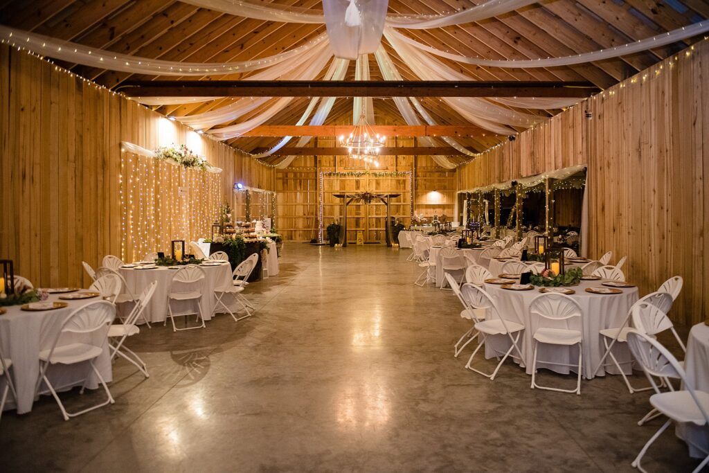 indoor photo of barn wedding with white tables and wood panels at the Barn at Willow creek 