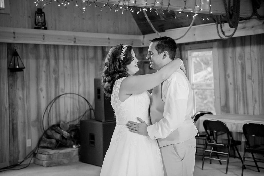 black and white image of bride and groom having their first dance in barn reception at Ransom Hollows